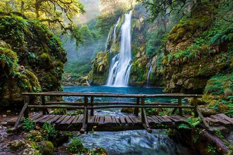 La Grande Cascade se déversant dans une piscine turquoise dans la gorge d’Akchour, montagnes du Rif, Maroc, avec une passerelle en bois traversant la rivière
