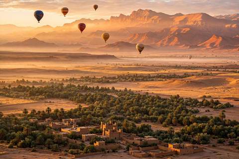 Montgolfières flottant au-dessus des plaines désertiques dorées près de Marrakech au lever du soleil, Atlas à l'horizon