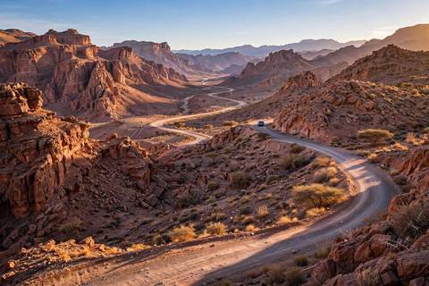 Une voiture de location sur une route de montagne marocaine pittoresque dans le Haut Atlas à l'heure dorée