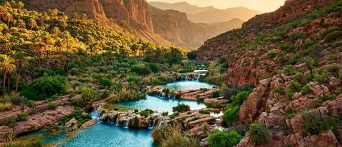 Piscines naturelles turquoise et petites cascades à Paradise Valley près d'Agadir, au Maroc, encadrées de palmiers et de falaises du Haut Atlas