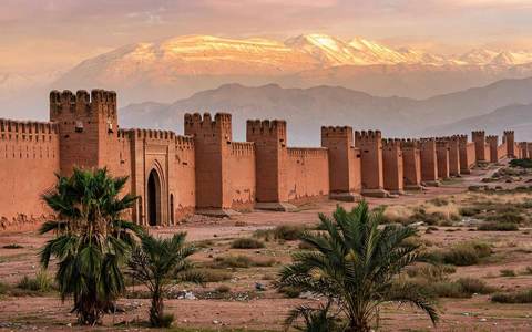 Les remparts ocres en pisé de Taroudant, au Maroc, au coucher du soleil, avec les contreforts du Haut Atlas derrière la médina
